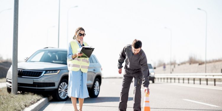 Woman and road assistance worker during the road accident on the highway